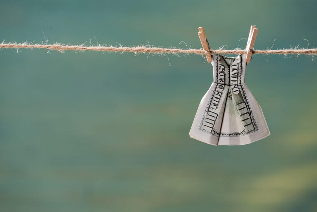 money folded in the shape of a dress hanging on a clothesline