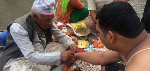 A Guru Brahmin binds are holy thread on wrist before giving him the holy thread for body known as Janai